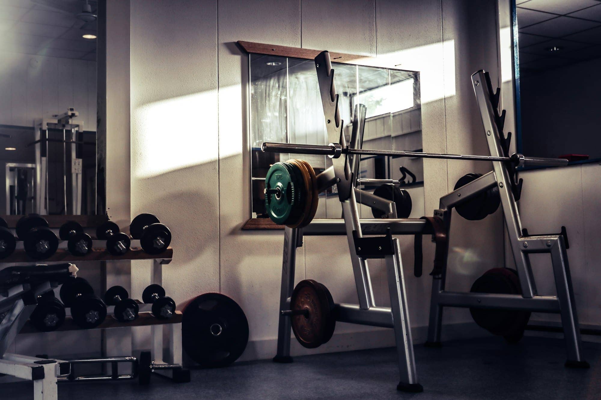 Strength — bench, rack and bar against raw plaster